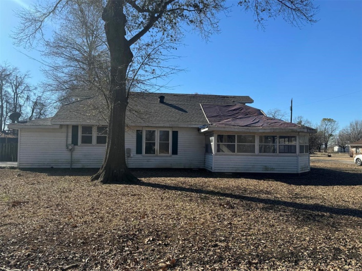 Back of property with a sunroom