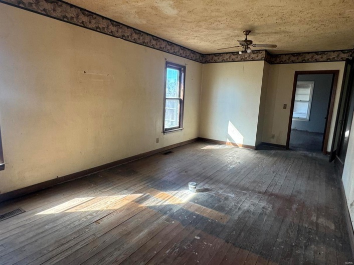 Spare room featuring ceiling fan, hardwood / wood-style floors, and a textured ceiling