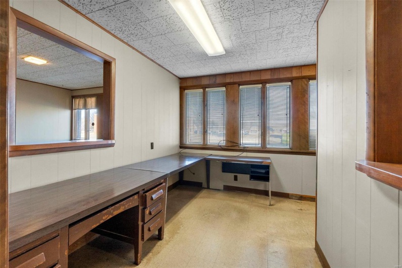 Home office featuring wooden walls and plenty of natural light
