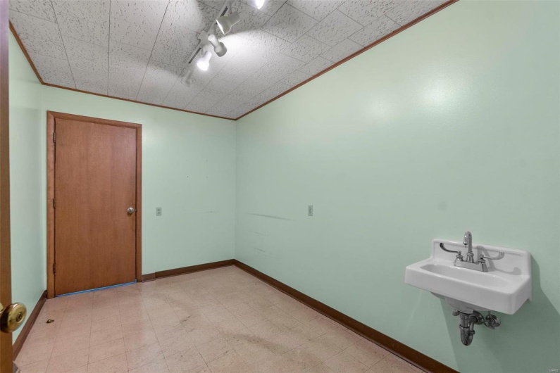 Unfurnished room with sink, ornamental molding, and rail lighting