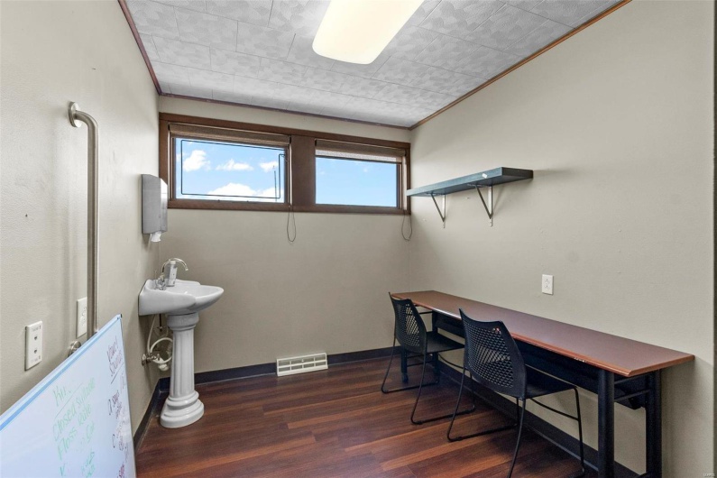 Bathroom with sink, wood-type flooring, and ornamental molding