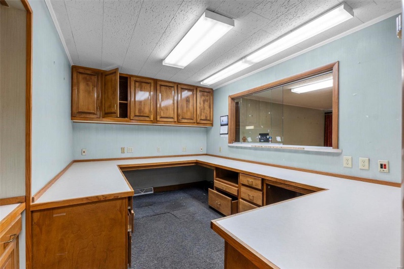 Office with ornamental molding and built in desk
