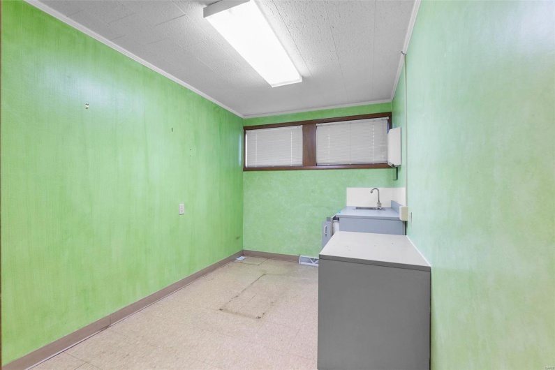 Laundry area featuring ornamental molding and sink