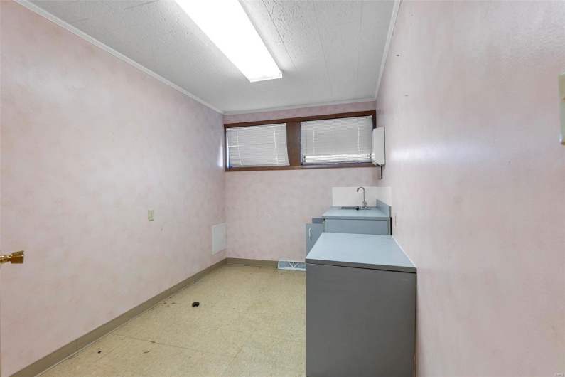 Laundry area with crown molding and sink