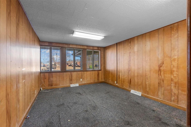 Carpeted empty room with wooden walls