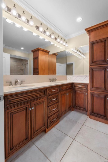 Bathroom featuring crown molding, tile patterned floors, and vanity