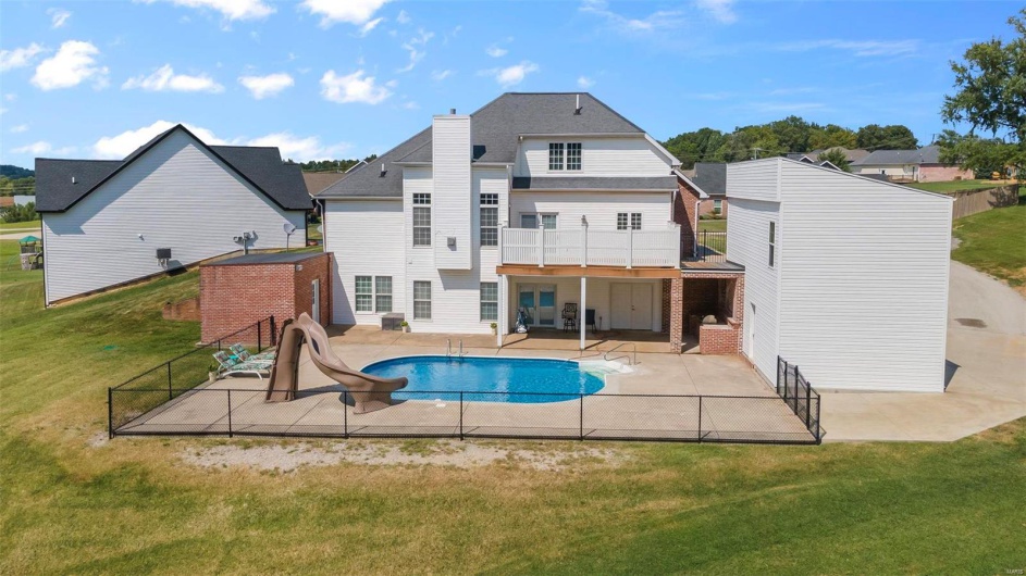 Back of house with a yard, a patio area, and a balcony