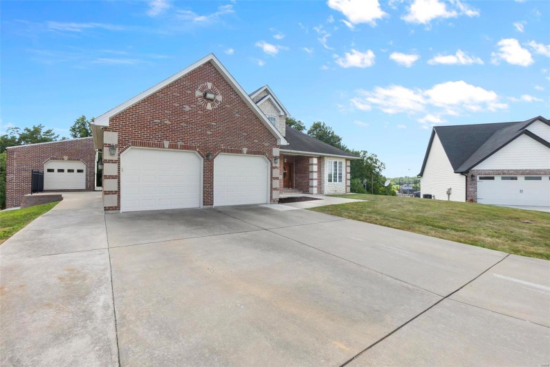 View of front facade featuring a garage and a front lawn