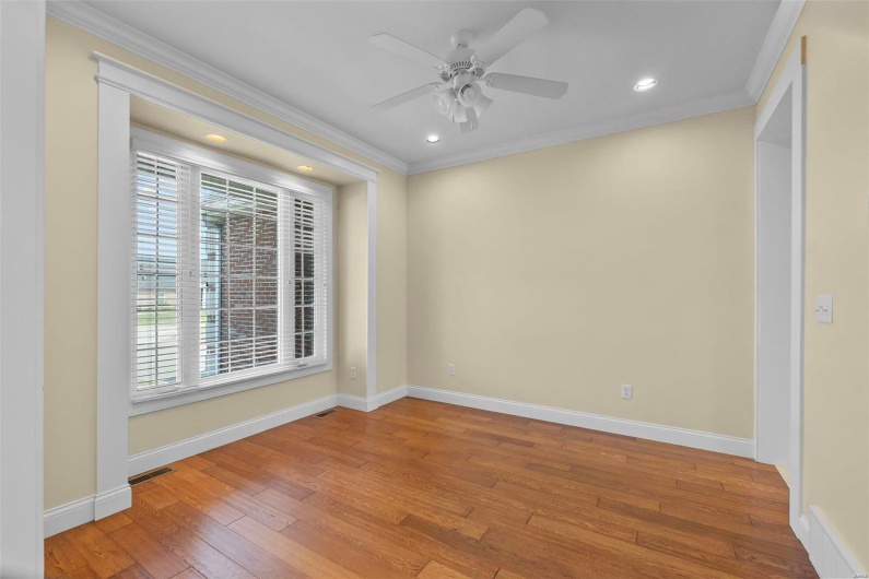 Spare room featuring crown molding, a healthy amount of sunlight, and light wood-type flooring