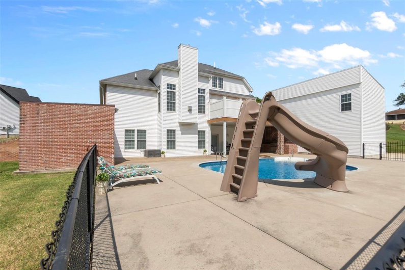 View of pool with a yard, a water slide, a playground, and a patio area