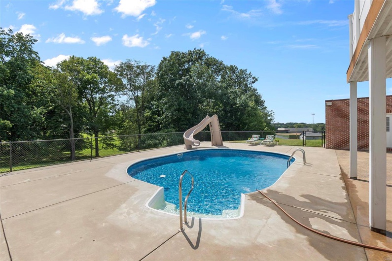 View of swimming pool with a patio and a water slide