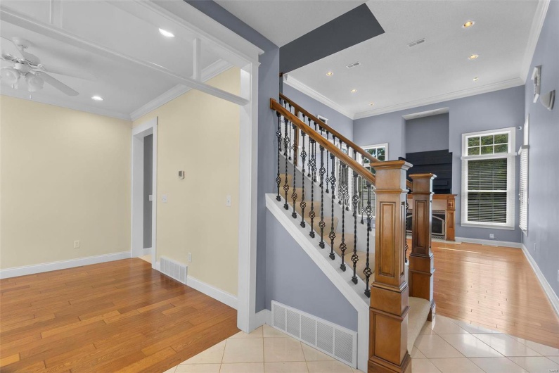 Stairs with crown molding and tile patterned floors