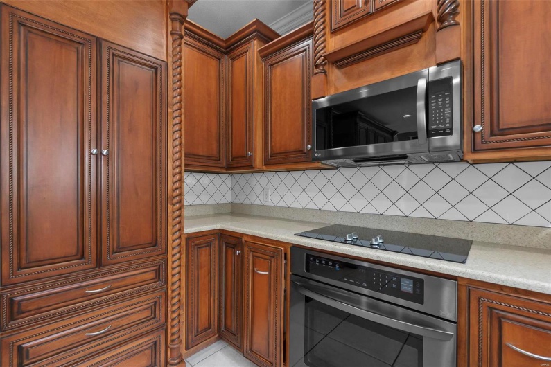 Kitchen featuring backsplash, built in desk, stainless steel appliances, and light stone countertops