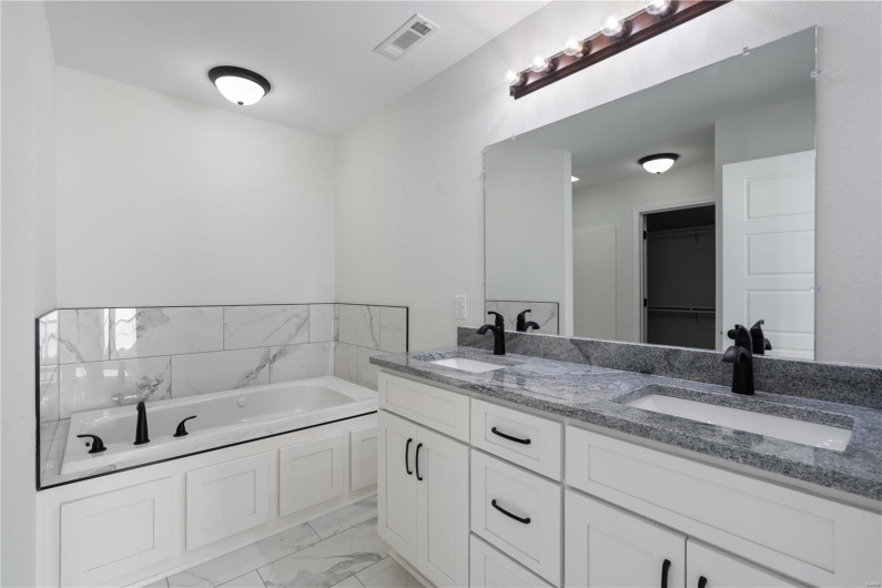 Bathroom featuring a washtub and vanity