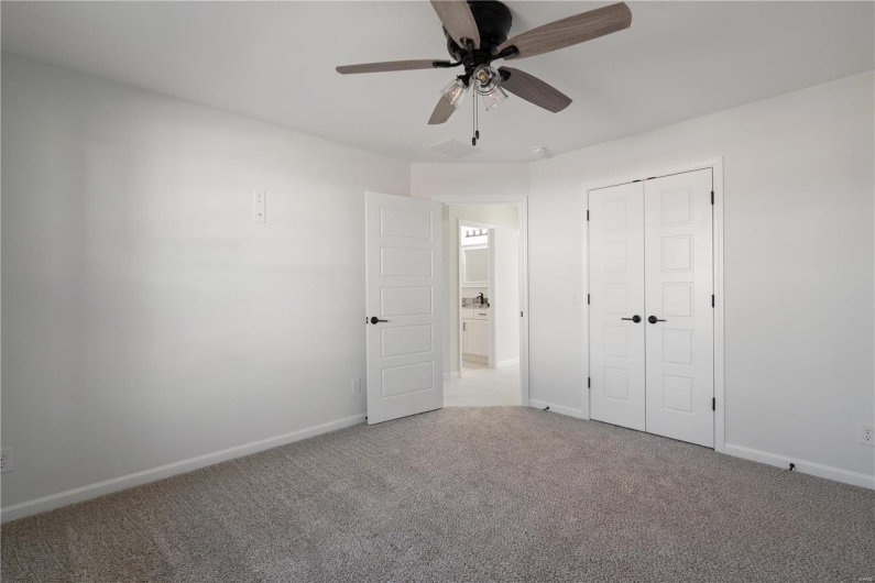 Unfurnished bedroom featuring light colored carpet, a closet, and ceiling fan