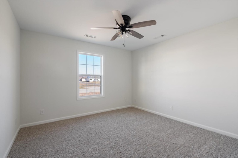 Carpeted spare room with ceiling fan
