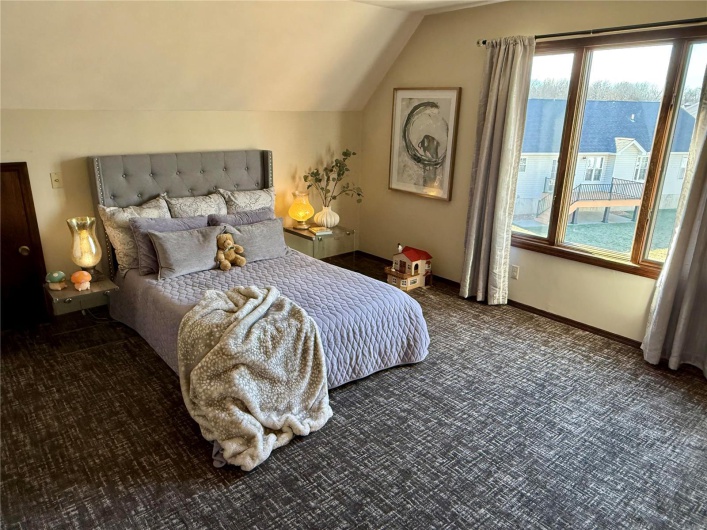 Bedroom featuring vaulted ceiling and dark colored carpet