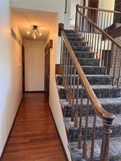Stairs featuring hardwood / wood-style flooring