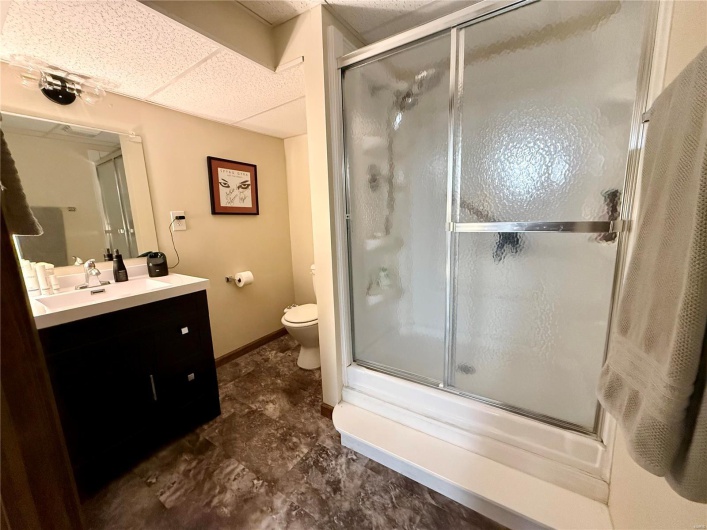 Full bathroom in basement featuring vanity, combined bath / shower with glass door, 