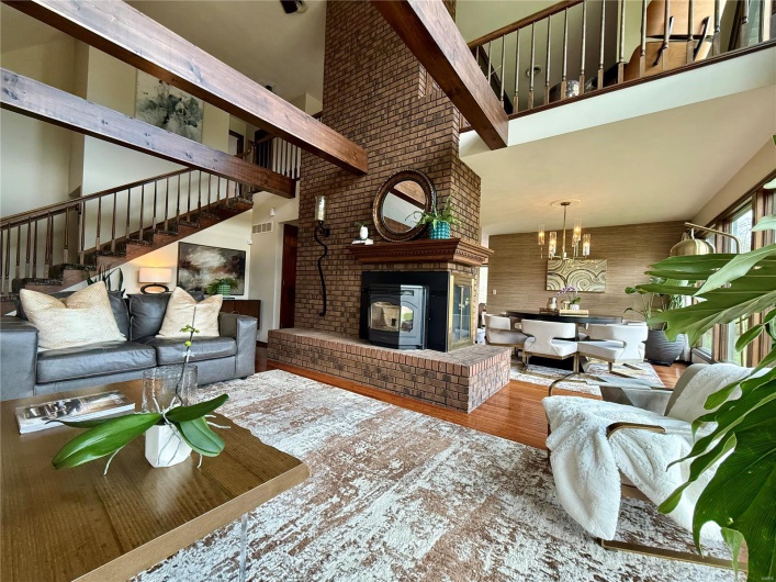 Living room with a high ceiling, wood finished floors, and stairs