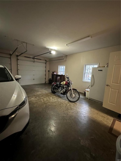 Garage featuring a garage door opener and refrigerator