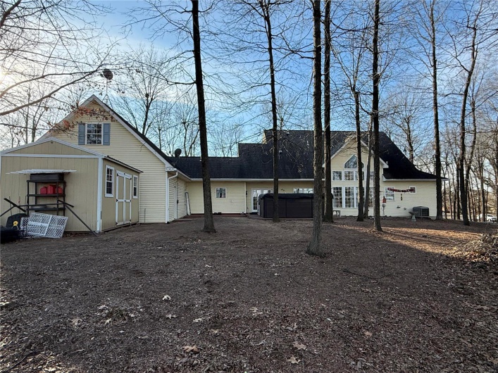 Back of house with a hot tub