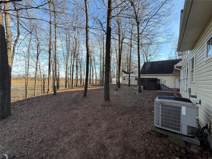 View of yard with a hot tub and central air condition unit
