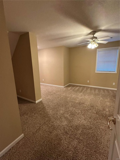 Spare room featuring ceiling fan, a textured ceiling, and carpet flooring