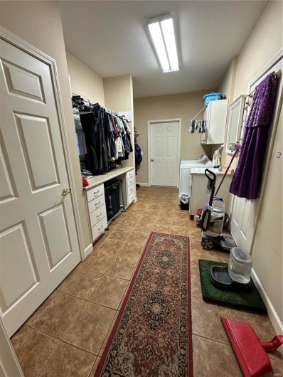 Spacious closet with light tile patterned flooring and washer and dryer