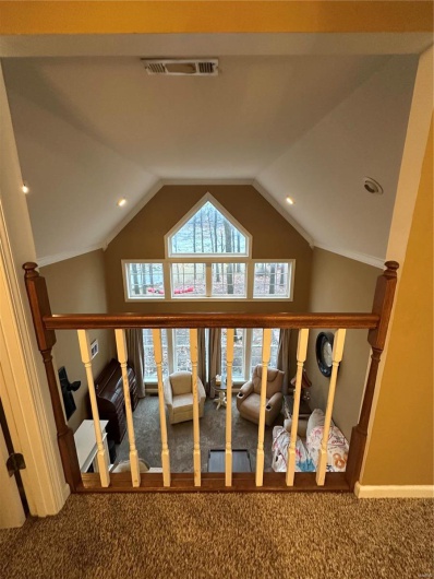 Stairway featuring lofted ceiling and carpet flooring