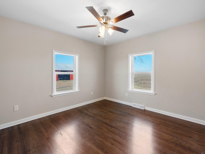 Empty room with dark hardwood / wood-style floors and ceiling fan