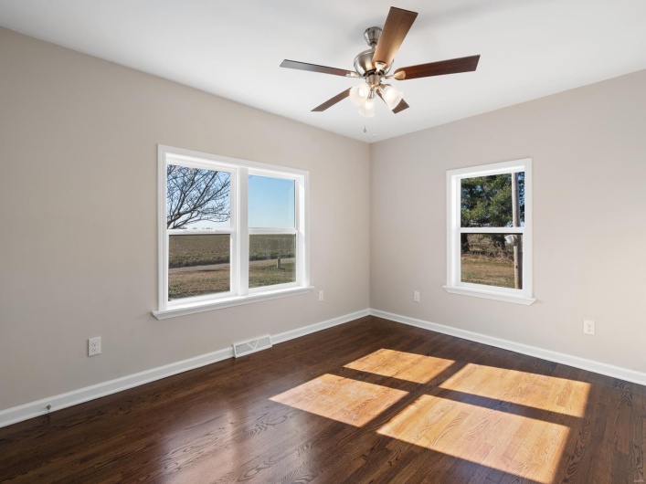 Unfurnished room with dark wood-type flooring and ceiling fan