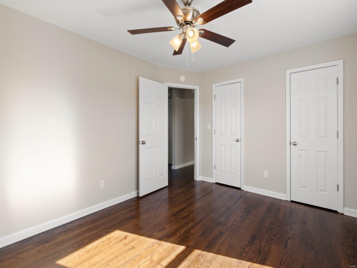 Unfurnished bedroom with dark hardwood / wood-style flooring and ceiling fan