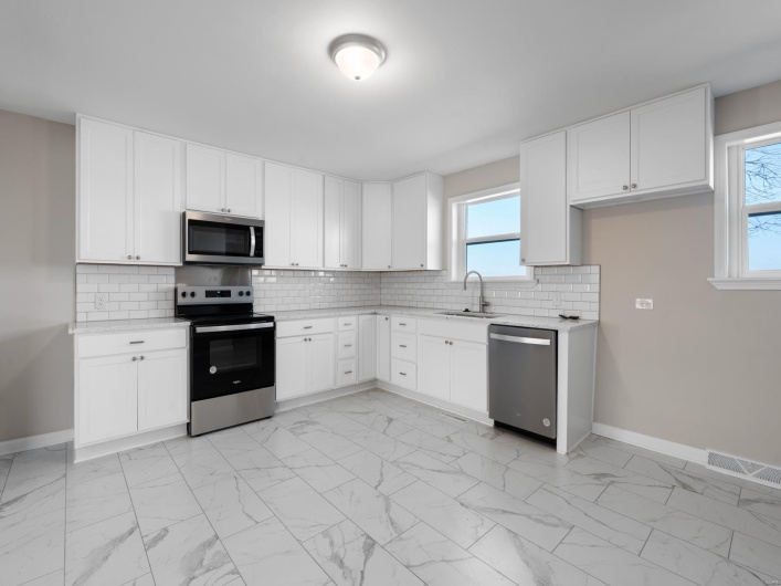 Kitchen featuring white cabinetry, appliances with stainless steel finishes, sink, and backsplash