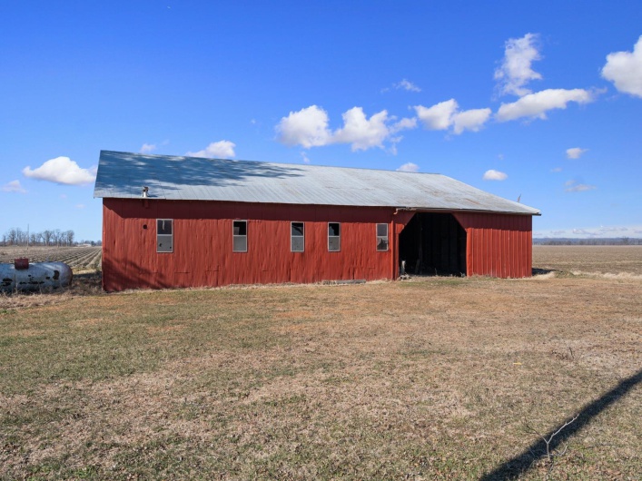 View of outdoor structure with a rural view and a yard