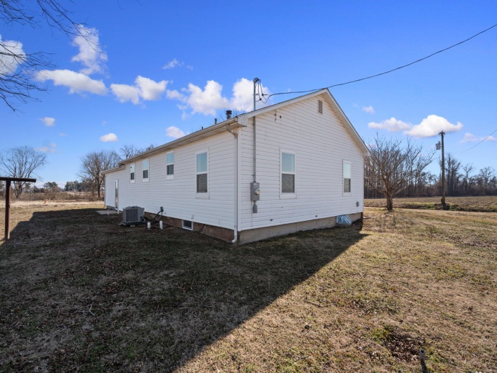 View of side of home with a yard and central AC unit