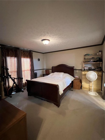 Bedroom featuring ornamental molding and a textured ceiling