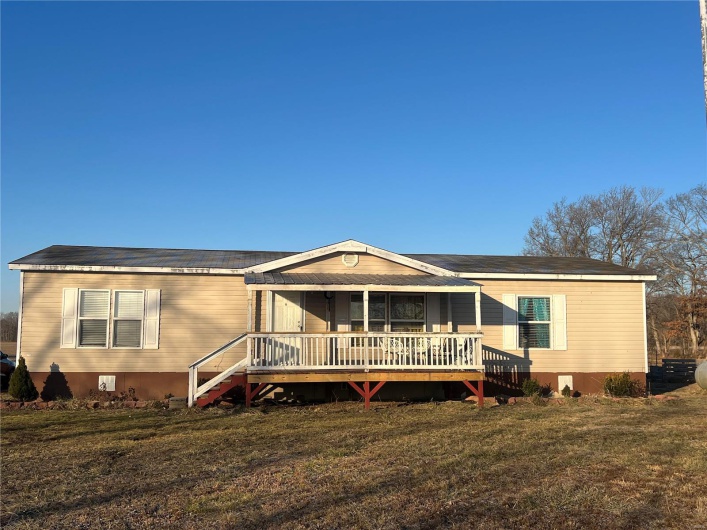 View of front of house with a front yard and a deck