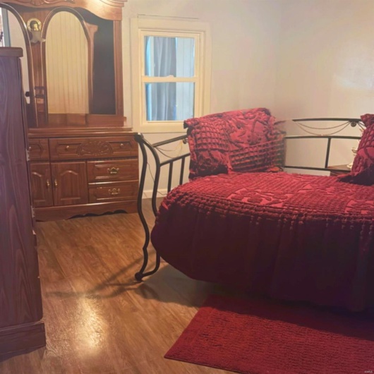 Bedroom with dark hardwood / wood-style floors