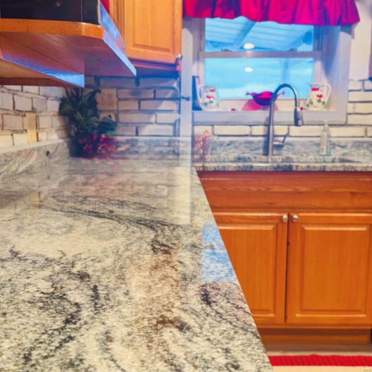 Kitchen featuring light stone counters and sink