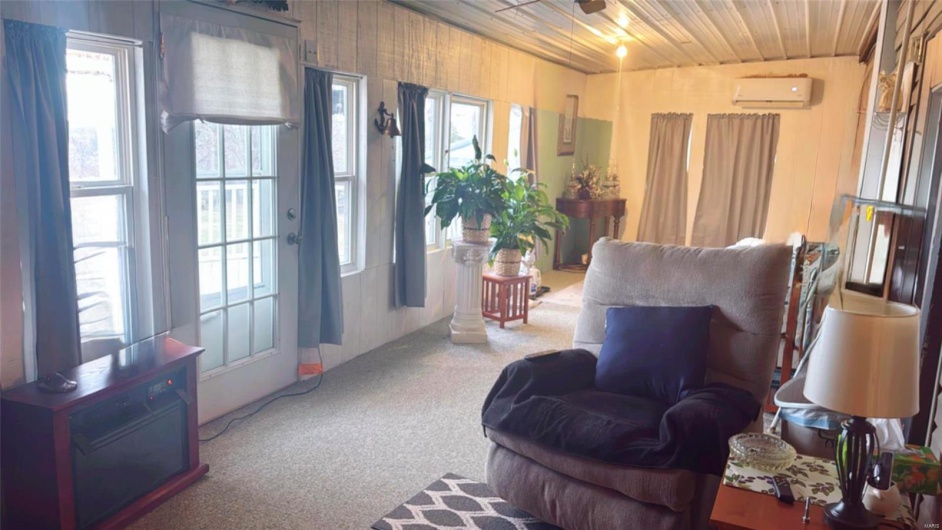 Sitting room with wood ceiling, an AC wall unit, and carpet