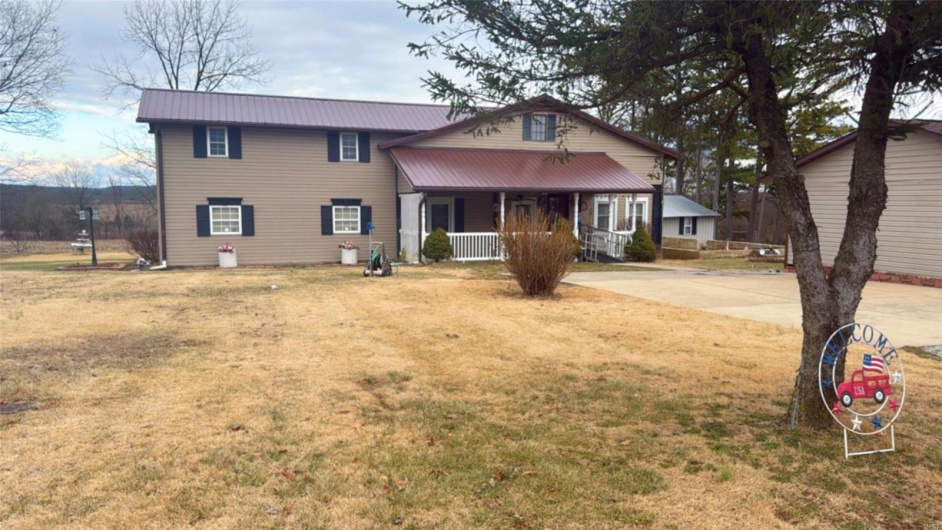 View of front of home with a porch and a front lawn