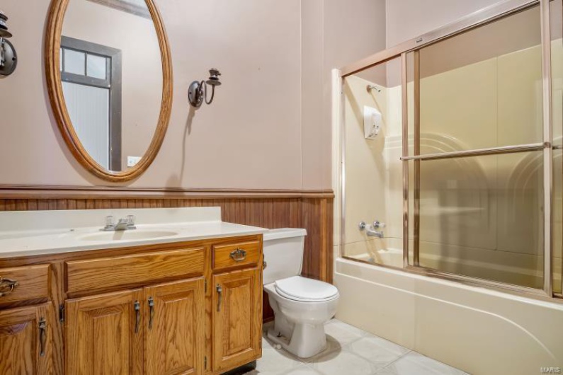 Full bathroom with vanity, shower / bath combination with glass door, and toilet