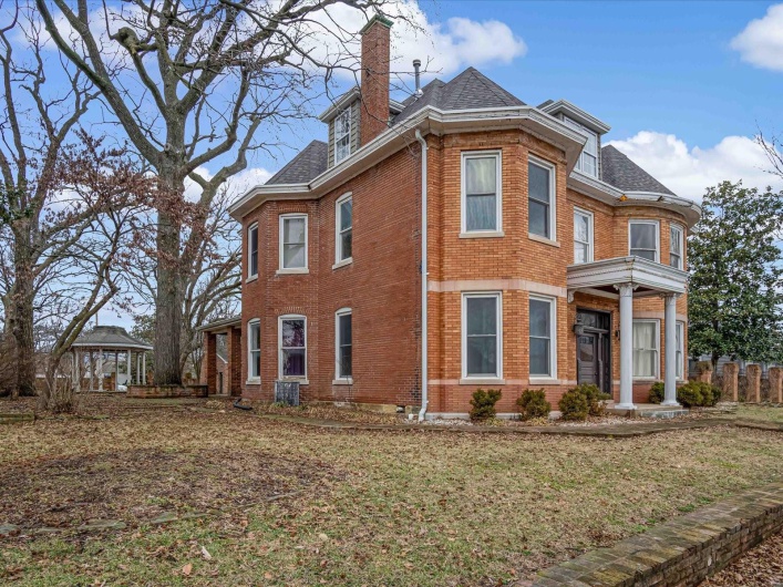 View of side of home featuring a yard