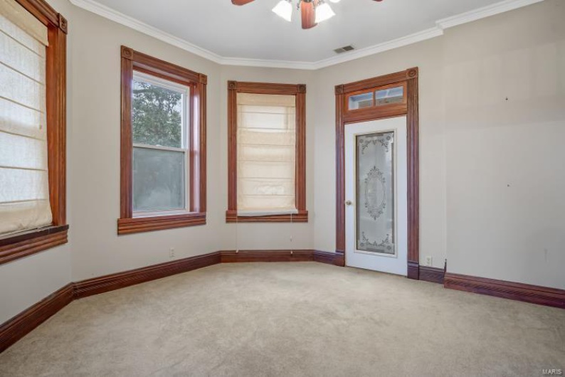 Carpeted empty room featuring crown molding and ceiling fan