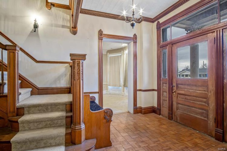 Foyer featuring an inviting chandelier and parquet flooring