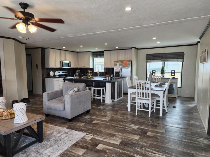 Living room featuring ceiling fan, ornamental molding, dark hardwood / wood-style floors, and sink