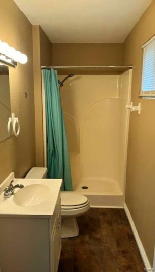 Bathroom with walk in shower, vanity, and toilet