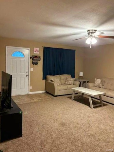 Living room with carpet flooring and ceiling fan