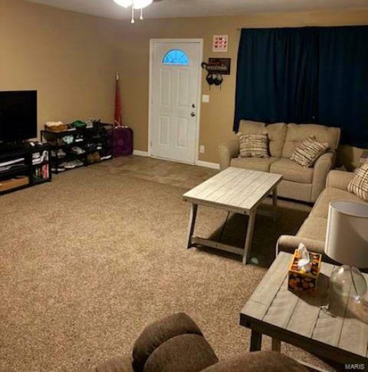 Living room featuring ceiling fan and carpet